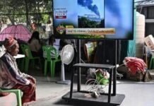 A displaced resident watches the news at an evacuation center in the Thai border province of Surin on December 11, 2025