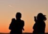 A family watches the last moments of twilight as the sun sets in Los Angeles, California, on March 18, 2026