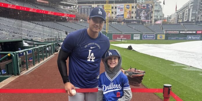 Young fan watches workout in the downpour, gets rewarded by Ohtani himself